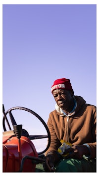 a man sitting in a red tractor