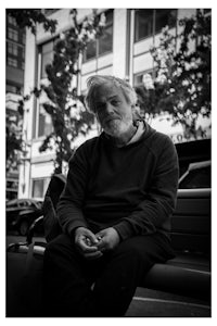 a man sitting on a bench with a beard