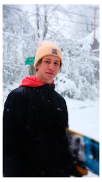 a young man holding a snowboard in the snow