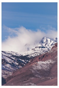 a mountain covered in snow with a blue sky