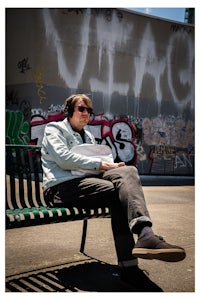 a man sitting on a bench with headphones on