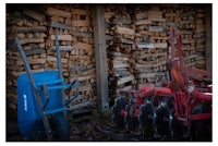 a pile of wood in front of a blue plow