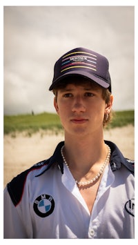 a young man wearing a bmw hat