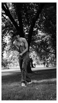 black and white photo of a man throwing a frisbee in a park