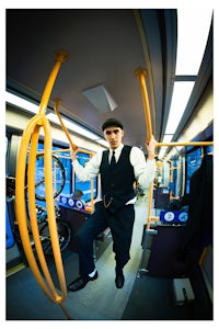 a man in a suit is hanging from a rope on a bus