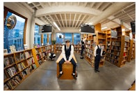 a man is sitting on a bench in a library