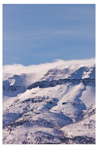 a mountain covered in snow with a blue sky