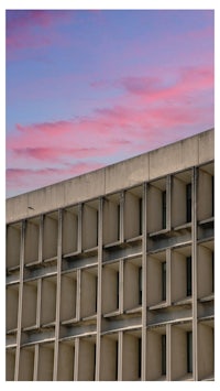 a building with windows and a pink sky