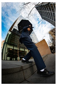 a man in a suit walking down steps with an umbrella