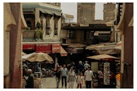 people walking down a narrow alley in a city