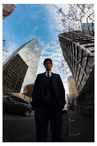 a man in a suit standing on a city street